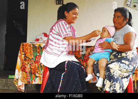 Guatemala, Salama, indigenen Mutter zubereiten und servieren Chispitas Ernährung Nahrung für Baby (Rosa Linda Sofia Tista Perez 10 Meses, Rosa Melida Gonzalez 49, Rosa Edilda Perez Gonzalez) Stockfoto