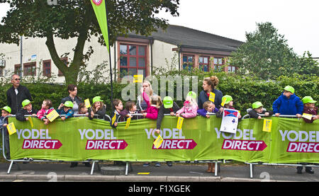 Abbeytown, Cumbria, UK. 8. September 2015. Kinder von Holm Cultram Abtei C of E Primary School stehen hinter Barrieren außerhalb ihrer Schule warten auf die Ankunft der Radfahrer, die Teilnahme an der Tour von Großbritannien 2015, Stufe 3. Bildnachweis: Julie Fryer/Alamy Live-Nachrichten Stockfoto