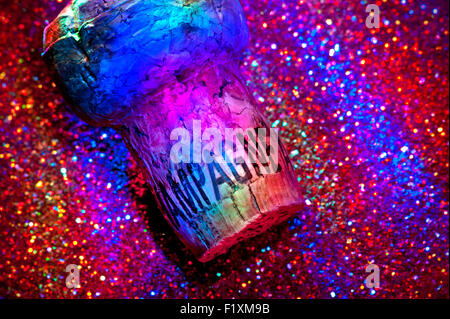 Sektkorken auf dem glitzernden Disco Club Clubbing Partytisch mit mehrfarbiger Party Club Beleuchtung Stockfoto