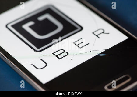 Das Symbol der Uber-Taxi-Service-app ist auf einem Smartphone hinter einen großen Sprung in den Touchscreen Glas angezeigt. Stockfoto