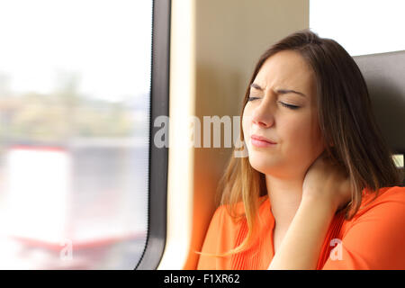 Betonte Frau mit Hals Schmerzen sitzen in einem Zug Wagen Beschwerden Stockfoto