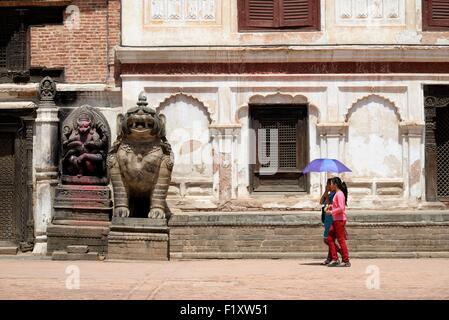 Nepal, Kathmandu-Tal, Bhaktapur, Weltkulturerbe der UNESCO, Frauen mit Sonnenschirm und Statuen am Durbar Square Stockfoto