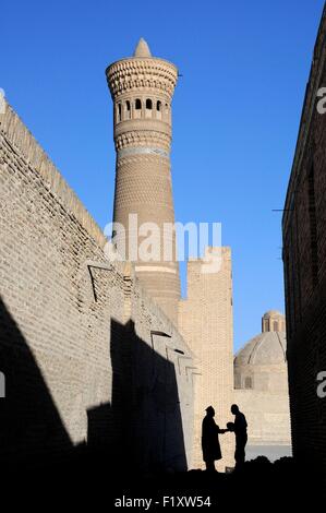 Usbekistan, Buchara, Altstadt Weltkulturerbe der UNESCO, Silhouette der beiden Männer Händeschütteln in einer kleinen Straße in der Nähe von Kalon Minarett Stockfoto