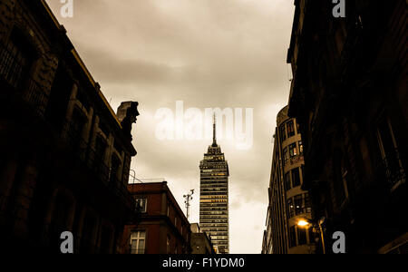 Torre Latinoamericana Wolkenkratzer Mexiko-Stadt Mexiko // MEXIKO-STADT, Mexiko – der Torre Latinoamericana erhebt sich aus dem Stadtzentrum und blickt von der Straße aus in die mexikanische Hauptstadt. Der 44-stöckige Art déco-Wolkenkratzer wurde 1956 fertiggestellt und erreicht eine Höhe von 181 Metern (594 Fuß), was ihn zu einem der bekanntesten Wahrzeichen von Mexiko City macht. Das vom Architekten Augusto H. Álvarez entworfene Gebäude wurde unter Verwendung innovativer Ingenieurtechniken errichtet, um seismischen Aktivitäten in der erdbebengefährdeten Region standzuhalten. Der Turm diente mehrere Jahrzehnte lang als das höchste Gebäude von Mexiko City und ist bis heute ein i Stockfoto