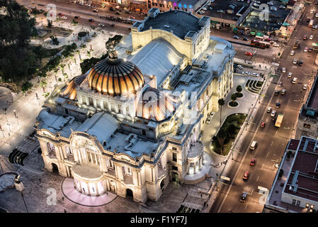Palacio de Bellas Artes Art Nouveau Copper Dome Mexiko-Stadt Mexiko / MEXIKO-STADT, Mexiko — die beleuchteten kupfergetönten Kuppeln des Palacio de Bellas Artes ankern das historische Zentrum, von der Aussichtsplattform im 44. Stock des Torre Latinoamericana aus gesehen. Der italienische Architekt Adamo Boari initiierte den Jugendstilentwurf 1904, der Bau des mexikanischen Nationaltheaters endete 1934. Stockfoto