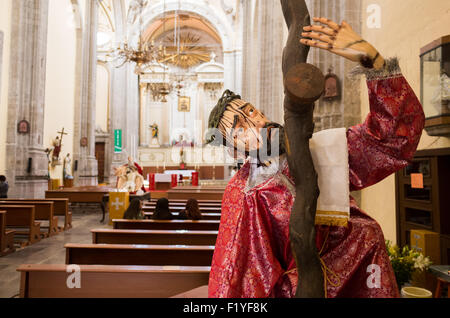 MEXIKO-STADT, Mexiko – Eine Statue, die Christus mit dem Kreuz in Iglesia de la Santisima Trinidad in Mexiko-Stadt darstellt. Iglesia de la Santisima Trinidad übersetzt als Kirche der Heiligen Dreifaltigkeit. Diese Kirche aus der Kolonialzeit dient weiterhin als Zentrum für religiöse und kulturelle Aktivitäten in der belebten Metropole. Stockfoto