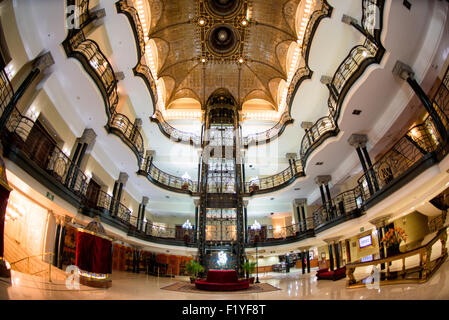 MEXIKO-STADT, Mexiko – Eine Weitwinkelaufnahme mit dem historischen Aufzug des reich verzierten Hauptfoyers des historischen Gran Hotel Ciudad de Mexico, mit seiner atemberaubenden Jugendstilarchitektur und der berühmten Tiffany-Buntglasdecke, blickt auf den Zocalo im Herzen des historischen Zentrums von Mexiko City. Stockfoto