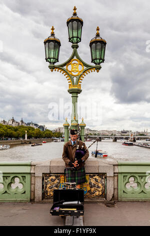 Ein Mann spielt Dudelsack auf Westminster Bridge, London, England Stockfoto