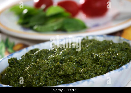 hausgemachte Genueser Pesto mit frischem Basilikum zubereitet und serviert in einer Keramikschale Stockfoto