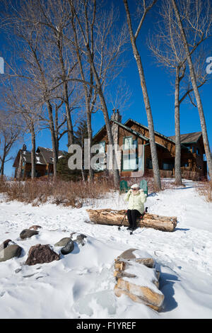 Ältere Frau passt ihr Kopftuch in Vorbereitung auf einen Spaziergang entlang der gefrorenen Ufer des Lake Superior an einem kalten Wintertag, zwei Harb Stockfoto