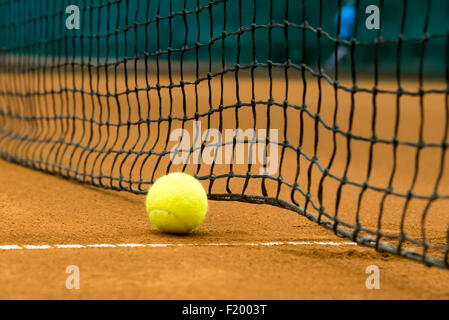 gelben Tennisball auf einem roten Sandplatz Stockfoto