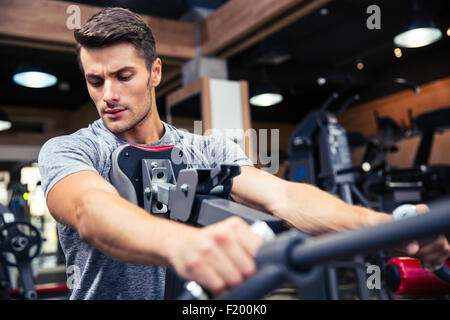Porträt eines jungen Mann-Trainings am Fitnessgerät in Turnhalle Stockfoto