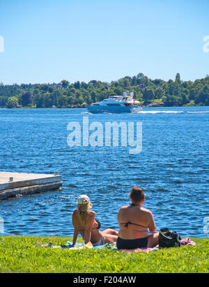 Zwei Damenuhr Sonnen eine Yacht, die Beschleunigung auf Mälarsee an einem sonnigen Sommertag im Augusti in Bromma, Stockholm, Schweden Stockfoto