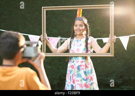 Mädchen auf der Suche durch Bilderrahmen, mit Foto Stockfoto