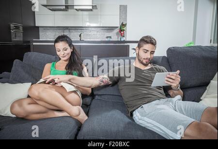 Junger Mann mit Freundinnen Buch auf sofa Stockfoto