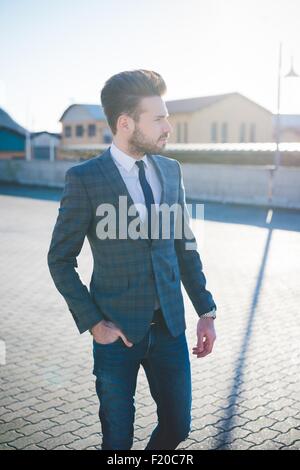 Stilvolle junger Mann zu Fuß mit der Hand in der Tasche Stockfoto