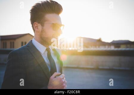 Stilvolle junge Mann trägt Farbtöne im Sonnenlicht Stockfoto