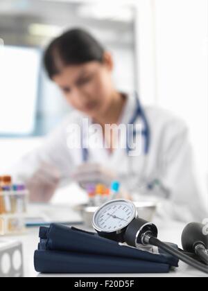 Ärztin untersucht Reagenzglas am Schalter in Klinik Stockfoto