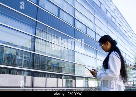 Junge Wissenschaftlerin Blick auf digital-Tablette außerhalb Labor Stockfoto