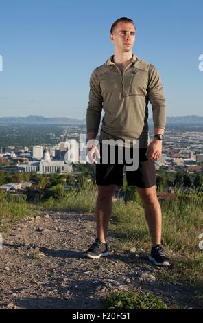 Porträt des jungen männlichen Läufer auf Feldweg oberhalb der Stadt im Tal Stockfoto