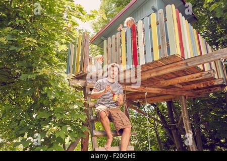 Porträt von Vater und zwei Söhne, die Malerei Baumhaus Stockfoto