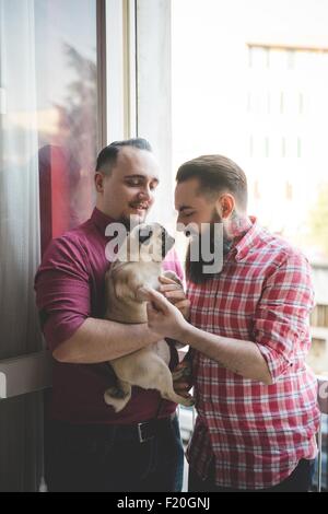 Gay paar mit Hund durch Fenster Stockfoto