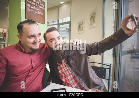 Gay paar nehmen Selfie im café Stockfoto