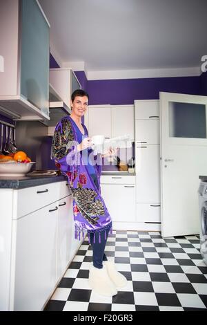 Frau lesen Papiere in Küche Stockfoto