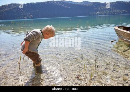 Junge paddeln und blickte in See, Kochel, Bayern, Deutschland Stockfoto