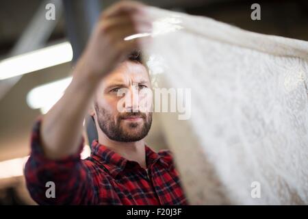 Männliche Weber Überprüfung Spitze Textil in alten Textilfabrik Stockfoto