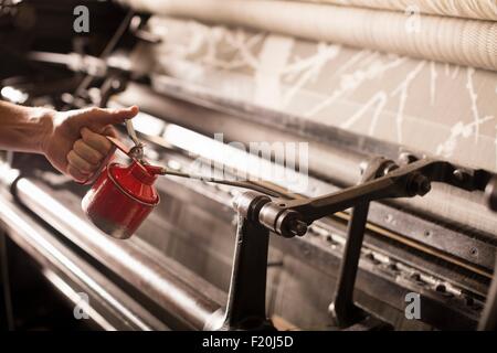 Hand von männlichen Weaver Ölen alte Webmaschine in Textilfabrik Stockfoto