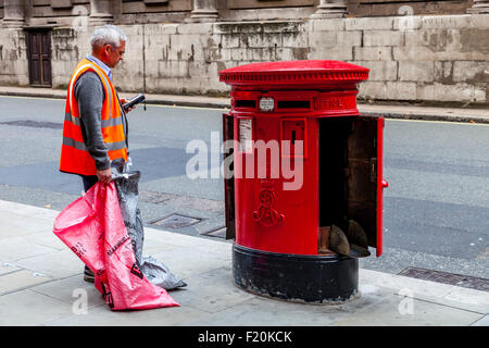 Ein Royal Mail Arbeiter sammelt die Mail von einem Briefkasten im Zentrum von London, England Stockfoto