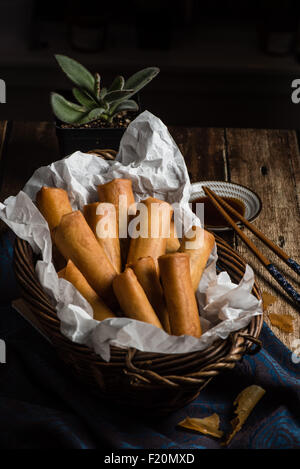 Traditionelle asiatische frittierte Frühlingsrollen mit Dip-Sauce auf hölzernen Hintergrund Stockfoto