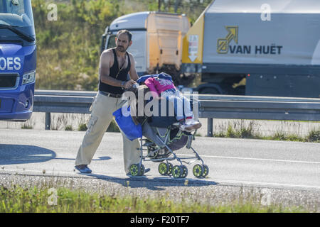 Kliplev, Dänemark. 9. Sep, 2015. Ein Mann schiebt einen Kinderwagen im Rahmen einer großen Anzahl von Flüchtlingen, die nördlich an der Straße entlang der dänischen E 45 Autobahn in der Nähe von Kliplev, Dänemark, 9. September 2015 gehen. Die Flüchtlinge wollen nicht in Dänemark registriert werden und versuchen, es zu Fuß nach Schweden zu machen. Foto: Benjamin Nolte/Dpa/Alamy Live News Stockfoto
