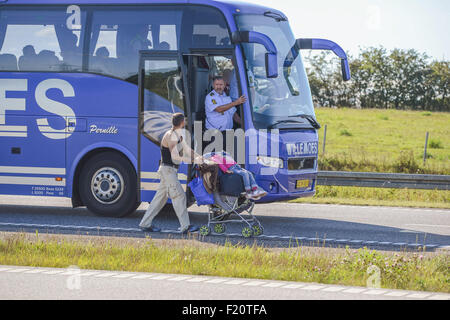 Kliplev, Dänemark. 9. Sep, 2015. Ein Mann schiebt einen Kinderwagen im Rahmen einer großen Anzahl von Flüchtlingen, die nördlich an der Straße entlang der dänischen E 45 Autobahn in der Nähe von Kliplev, Dänemark, 9. September 2015 gehen. Der Mann lehnt das Angebot, in den Bus zu reisen. Die Flüchtlinge wollen nicht in Dänemark registriert werden und versuchen, es zu Fuß nach Schweden zu machen. Foto: Benjamin Nolte/Dpa (Kind im Inneren des Busses gepixelten) / Dpa/Alamy Live News Stockfoto