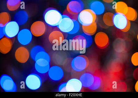 Einen hellen mehrfarbigen Bokeh Hintergrund erstellt durch eine Reihe von de-fokussierten Weihnachtsbeleuchtung. Stockfoto