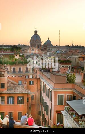 Italien, Latium, Rom, Altstadt als Weltkulturerbe der UNESCO, Panoramablick aufgeführt von Trinitα dei Monti, mit San Carlo al Corso Cupula und Saint Peter Cupula im Hintergrund, Menschen beobachten Sonnenuntergang Stockfoto