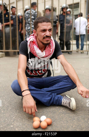 Beirut, Libanon. 8. Sep, 2015. Ein libanesischer Demonstrant sitzt vor Polizisten während einer Protestaktion Kündigung Libanons stagnierende politische System, das das Ziel von Demonstrationen nach einer Müll-Krise in Beiruts Märtyrer-Platz, am 9. September 2015 geworden ist. Verärgert durch bröckelnde Infrastruktur und politische Lähmung Beiruts Straßen wieder mehr als Parteiführer fehlgeschlagen zu Ergebnissen bei den Gesprächen über den Stillstand zu beenden libanesischen Demonstranten © Marwan Bouhaidar/APA Bilder/ZUMA Draht/Alamy Live News Stockfoto