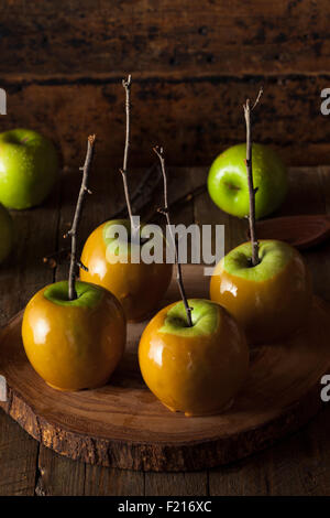 Hausgemachte grüne Äpfel mit Karamell auf einem Stick für Halloween Stockfoto