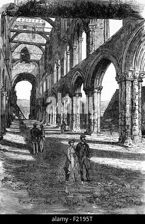 Besucher aus dem 19th. Jahrhundert besuchen die Jedburgh Abbey, eine ruinierte Augustinerabtei aus dem 2th. Jahrhundert, die an den schottischen Grenzen nur 10 Meilen (16 km) nördlich der Grenze zu England gegründet wurde. Nach der Niederlage des Earl of Surrey in 1297 in Stirling in den Händen von William Wallace, die Abtei wurde geplündert und zerstört von den Engländern als Vergeltung. Weitere Schäden an der Abtei trat während der anglo-schottischen Schlachten, bis die große Abtei von St. Mary von Jedburgh wurde schließlich ruiniert mit dem Kommen der schottischen Reformation in 1560. Stockfoto