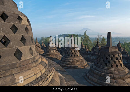 Indonesien, Java, Borobudur, Early-Morning, nebligen Blick über Stupas und die Landschaft zum Vulkan Mount Merapi Stockfoto