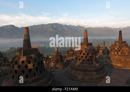 Indonesien, Java, Borobudur, Early-Morning, nebligen Blick über Stupas und die Landschaft zum Vulkan Mount Merapi Stockfoto