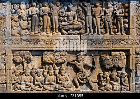 Indonesien Java Borobudur zwei-tiered Bas Relief zeigt sitzenden Buddha und Anhänger auf die oberste Stufe und Soldat oder König mit Bogen und Stockfoto