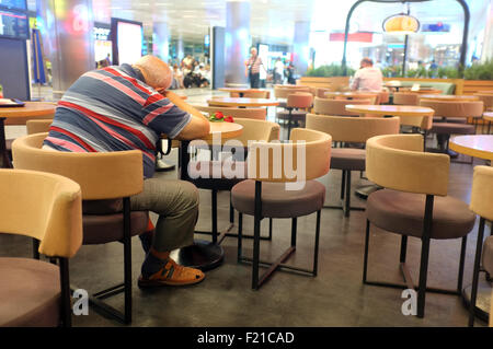 Alter Mann schläft auf dem Tisch Stockfoto