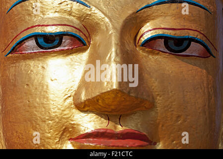 Nepal, Kathmandu, close-up of Gold bemalte Gesicht eines stehenden Buddha-Statue auf dem Weg zum Affentempel Swayambhunath Tempel. Stockfoto