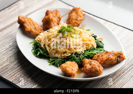 Chicken Wings mit Nudeln und Spinat Stockfoto