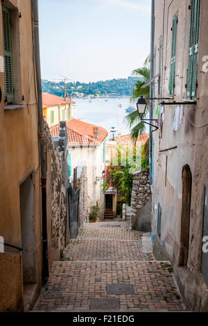 Schmale Straße mit alten Gebäuden führt zu Mittelmeer in der mittelalterlichen Stadt Villefranche-Sur-Mer an der Côte d ' Azur, Frankreich. Stockfoto