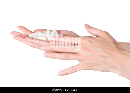 Frauenhand mit Handvoll Kapseln isoliert auf weißem Hintergrund mit Beschneidungspfad Stockfoto
