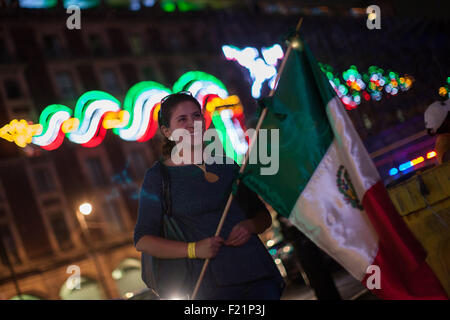 Mexico City, Mexiko. 9. Sep, 2015. Eine Frau hält einen mexikanischen Nationalflagge vor der Neonröhren vor der Feier der 205. Jahrestag der mexikanischen Unabhängigkeit in Mexiko-Stadt, Hauptstadt von Mexiko, am 9. September 2015. Mexiko feiert am 16. September die 205. Jahrestag seiner Unabhängigkeit. © Pedro Mera/Xinhua/Alamy Live-Nachrichten Stockfoto