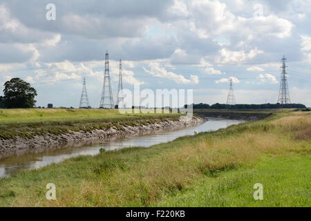 Überirdische Stromleitungen überspannen den Fluss Nene auf Foul Anchor, Cambridgeshire, mit Strom aus Sutton Bridge-Kraftwerk. Stockfoto